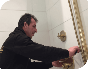 A professional plumber fixing shower taps