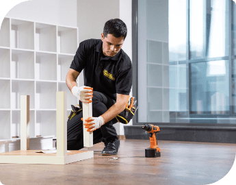 An expert attaching wooden parts to assembly furniture