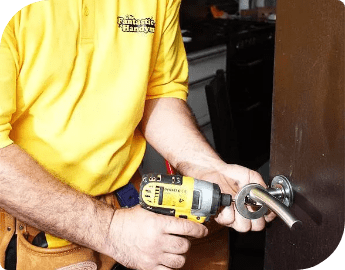 A handyman fixing a door lock