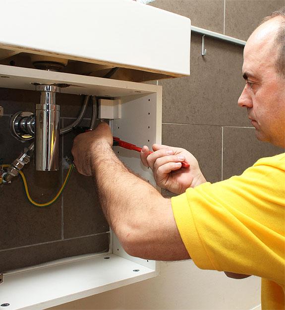 Plumber fixing a bathroom leak.
