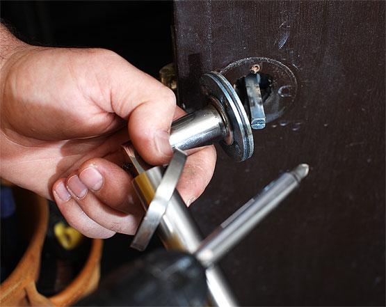 Locksmith repairing a door lock