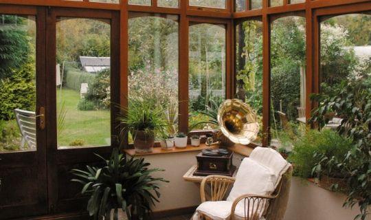 a conservatory with beautiful vegetation and a view to the garden outdoors