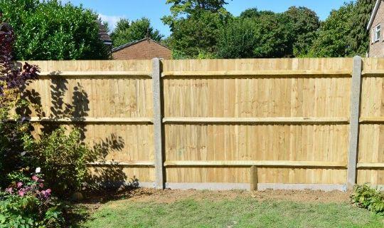 a wooden fence with concrete posts