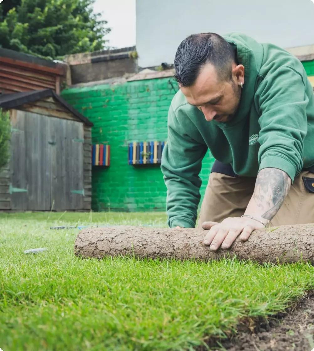 A gardener turfing a real grass