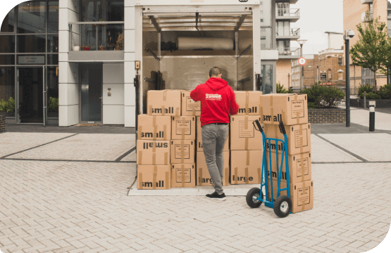 Removalist with a hand truck who prepares boxes for an international move.
