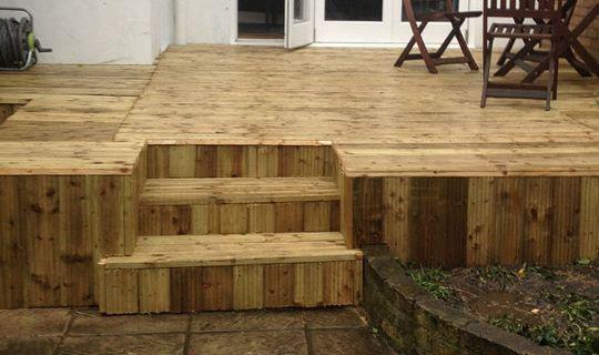 a wooden decking area with chairs and a table