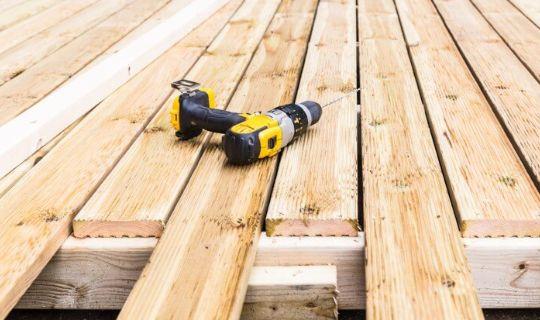 wooden decking boards and a drilling tool