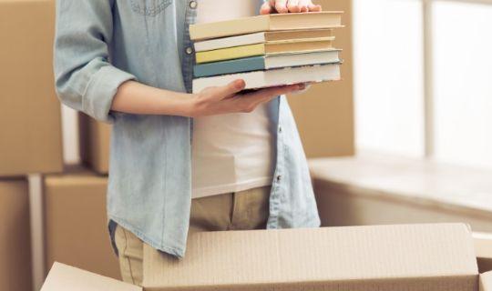 a woman carrying books in her hands