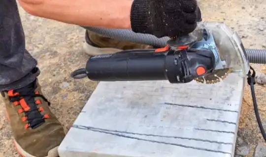 a man using a tool to make cuts for paving slabs