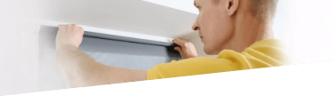 A handyman installing a curtain rail