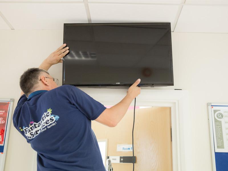 Handyman mounting a TV to the wall