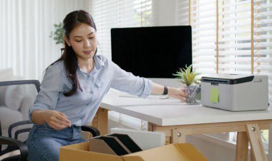 a woman packing her home office items and preparing for a relocation