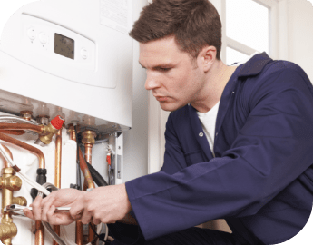 A boiler repair technician working on a faulty boiler unit