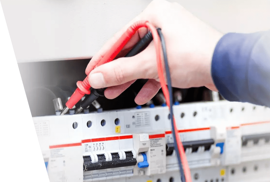 A professional's hands working on a fuse box