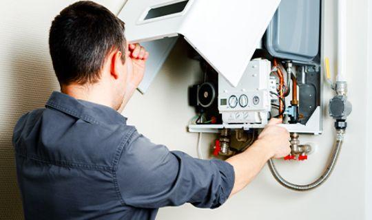 an expert looking at the insides of an opened boiler