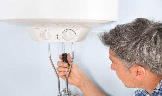 a professiomnal using a tool to work on a boiler