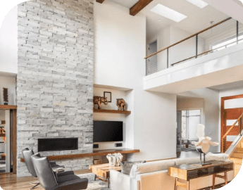 Modern living room with high ceiling, stone fireplace, and mezzanine.