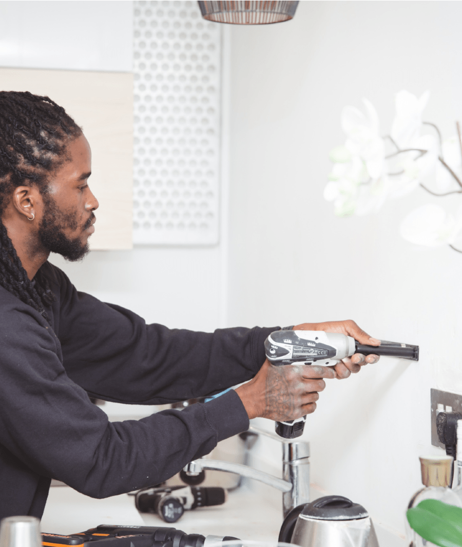 handyman drilling hole in the wall