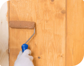 Close-up of the hand of a professional who is applying resin filler to wood flooring.