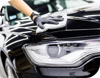 Close-up of the hand of a professional polishing a black car.