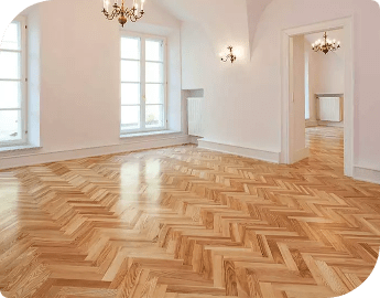 Herringbone parquet flooring in elegant empty room with chandeliers.