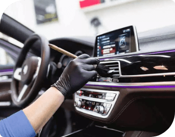 A valeting professional thoroughly cleans the interior of a car