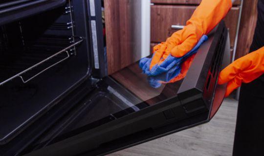 a professional cleaning a rangemaster oven door from the inside