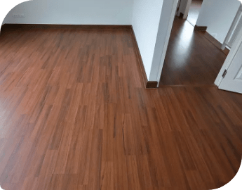 A well-lit room featuring brown wooden laminate floors, showcasing a professional laminate floor fitting service.