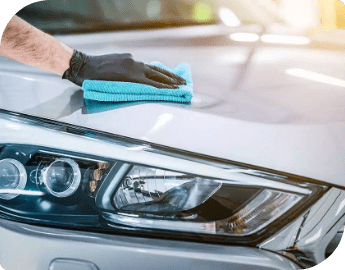 Picture of the hand of a professional cleaning the exterior of a car during a mobile car valeting service.