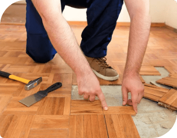 Close-up of a professional performing parquet floor repair service.