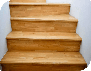 Professionally sanded and restored wooden stairway against a white wall.