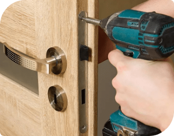 A professional using a drill to install door handle