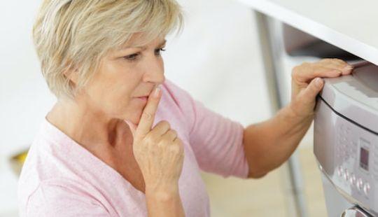 a woman with her hand placed on her washing machine