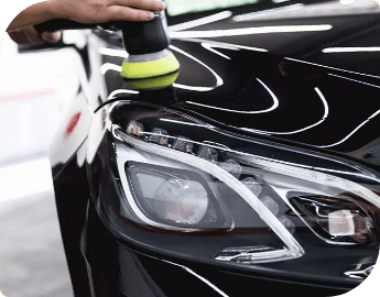 Person polishing a black car with a buffer