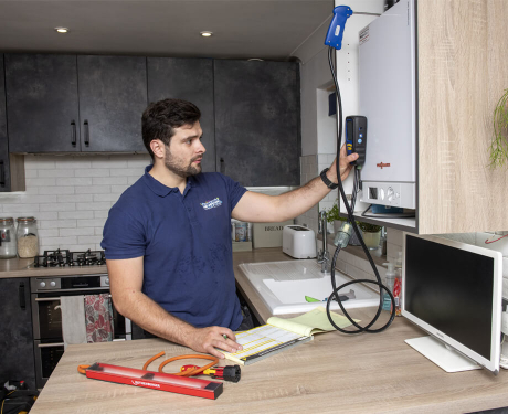 Gas Safety plumber while checking a boiler