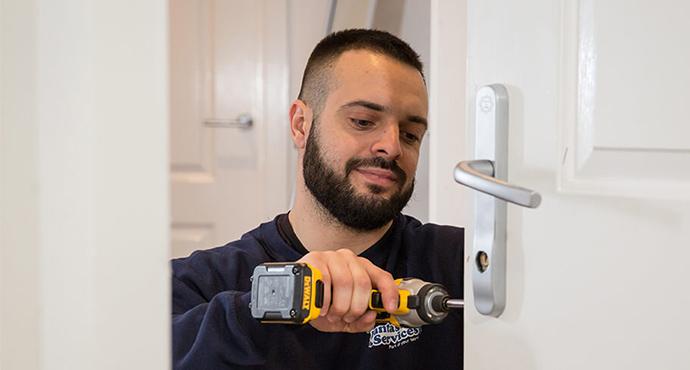 Professional lock specialist is installing a new door lock