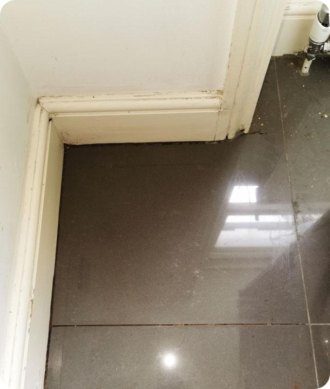 An image of a spotlessly clean corner of a room behind a home appliance, shining with freshness. The dust, cobwebs, and dirt accumulation have been completely removed, revealing a pristine corner. The walls and baseboards are free from any debris or cobwebs, and the floor gleams with a shiny clean appearance. The corner looks immaculate and well-maintained, ready to enhance the overall cleanliness of the room.