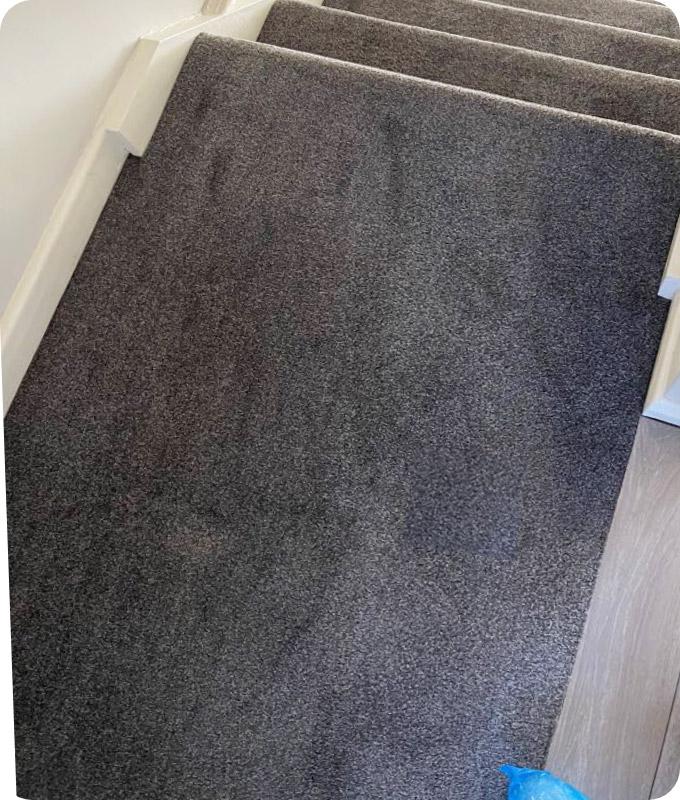 A grey-blue carpeted stairs that look absolutely fantastic and clear of any smudges and stains after our professional cleaning service.