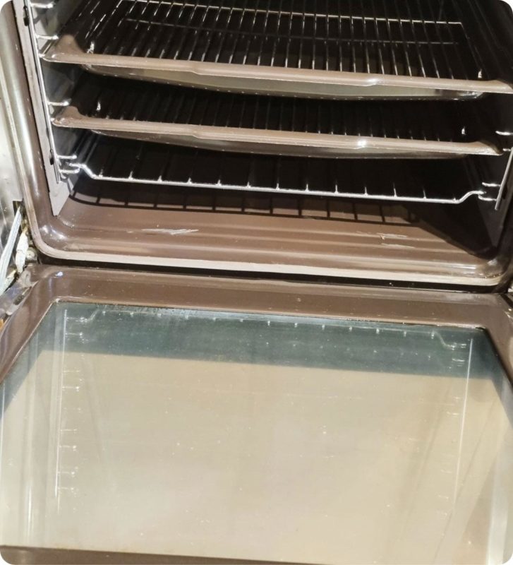 Open oven after professional cleaning, showcasing a spotless interior.
