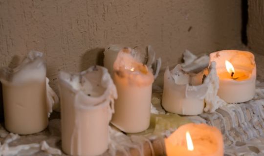 different colours molten candles positioned next to a wall