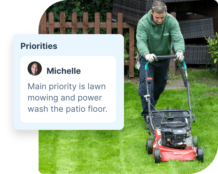 The image shows a professional gardener who is mowing a lawn with a red lawn mower.