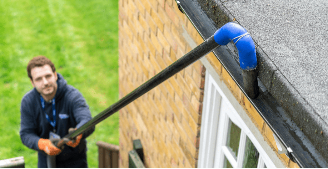 Gutter cleaner cleaning gutters with gutter cleaning machine