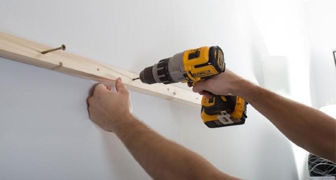 handyman drilling hole in the wall