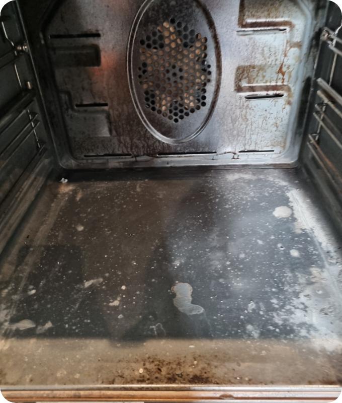 The image shows a close-up of an oven chamber that appears highly neglected. It is caked with various food splatters and crusty stains from cooking.