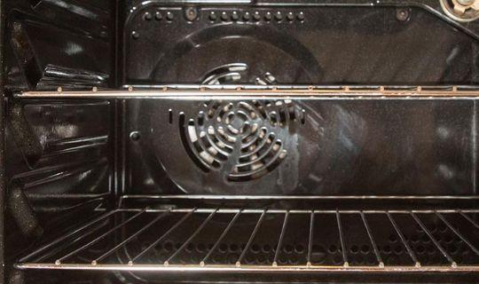 the inside of an oven with a fan and two oven racks