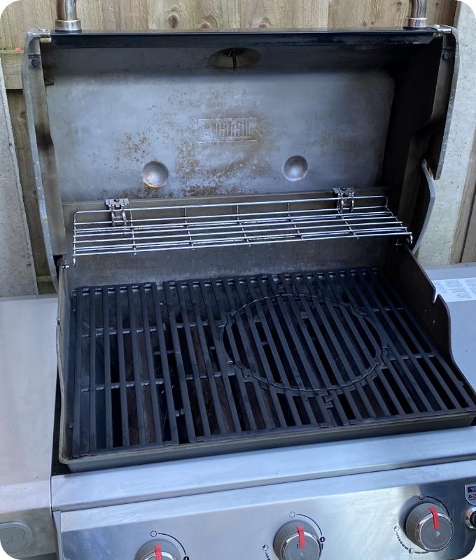The image shows the same grill after it has been professionally cleaned. The lid and grill rack appear to be cleaned.
